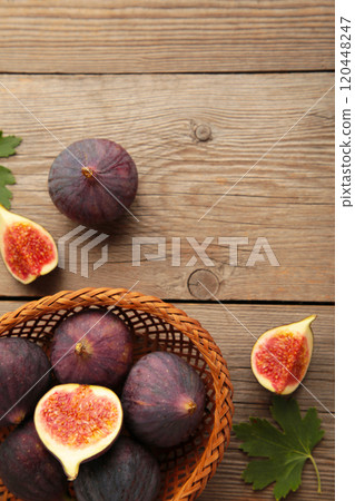 Group of figs in a wooden bowl on grey background. Vertical photo. 120448247