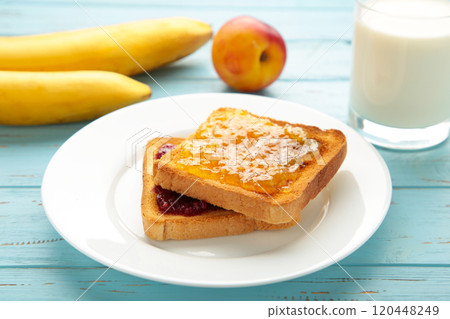 Sweet toasts with jam for breakfast on blue table 120448249