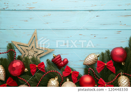 Christmas frame - tree branches with red and gold baubles, stars, snowflakes on blue background. 120448330