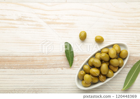 Fresh olives in bowl with leaves on white background with copy space. 120448369