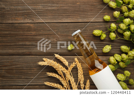Beer bottle with hop cones and wheat on grey background, close up. 120448411