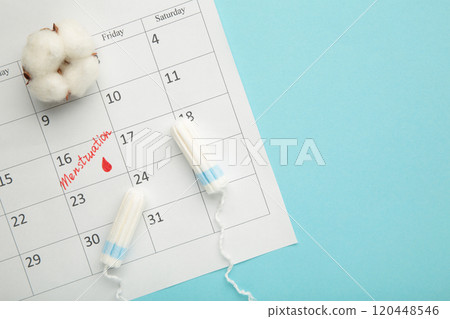 Menstruation calendar with cotton tampons and pads on blue background. Woman critical days, woman hygiene protection. Menstrual pain 120448546