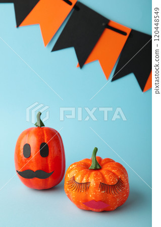 Halloween pumpkin with make up on blue. Minimal Holiday season concept background. Man and woman. Vertical photo Halloween pumpkin with make up on blue. Minimal Holiday season concept background. Man and woman. Vertical photo 120448549