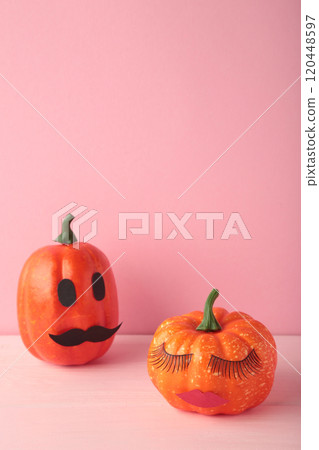 Halloween pumpkin with make up on pink. Minimal Holiday season concept background. Man and woman. Vertical photo 120448597