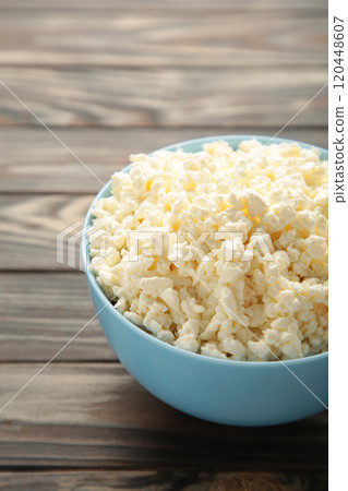 Homemade cottage cheese in a bowl on brown background. 120448607