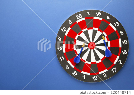 Dart board with blue darts on blue background. Dart board with blue darts on blue background. 120448714