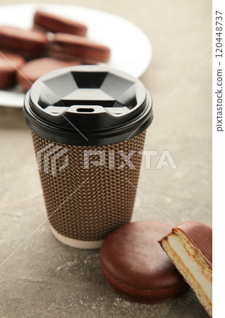 Choco pie chocolate coated snacks with cup of coffee on grey background. Vertical photo. Choco pie chocolate coated snacks with cup of coffee on grey background. Vertical photo. 120448737