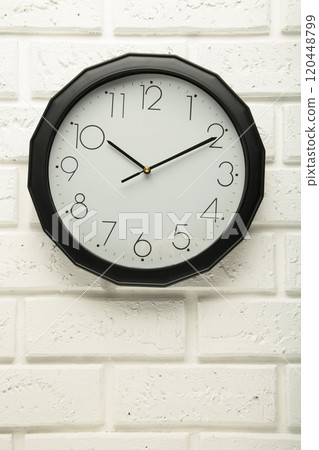 Black wall clock on the white wall background. Black wall clock on the white wall background. 120448799