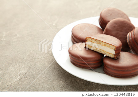 Choco pie chocolate coated snacks in plate on grey background. Choco pie chocolate coated snacks in plate on grey background. 120448819