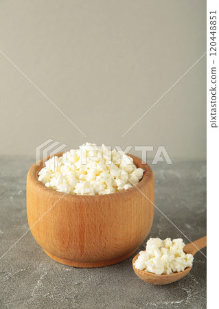 Cottage cheese for breakfast in wooden bowl on grey background. 120448851