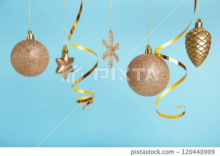 Golden christmas balls with ribbon on blue background with copy space. New Year 2022 Golden christmas balls with ribbon on blue background with copy space. New Year 2022 120448909