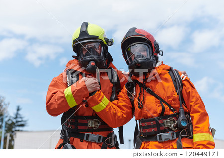 A unified team of firefighters, adorned in their uniforms, engages in a heartfelt celebration marked by triumphant salutes and cheers, embodying the joy and gratitude following the successful 120449171