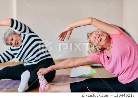 Senior Women Embrace Wellness: Yoga and Stretching in a Sunlit Space 120449212