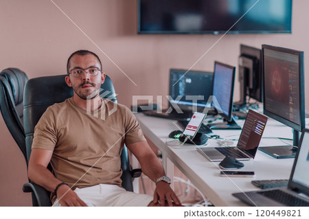 A programmer diligently testing smartphone applications while sitting in their office. A programmer diligently testing smartphone applications while sitting in their office. 120449821
