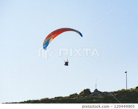Paraglider flying in blue sky. Paraglider flying in blue sky. 120449905