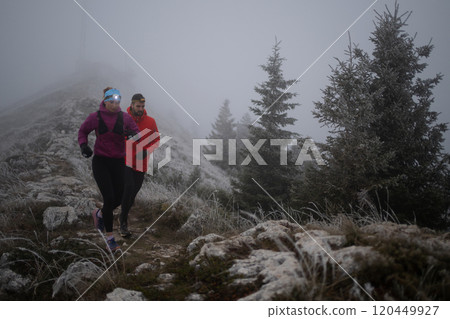 trail running couple man and woman running on a mountain path trail running couple man and woman running on a mountain path 120449927