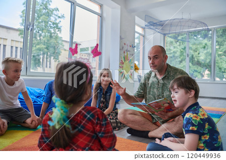 Reading time in an elementary school or kindergarten, a teacher reading a book to children in an elementary school or kindergarten. The concept of pre-school education. Selective focus Reading time in an elementary school or kindergarten, a teacher reading a book to children in an elementary school or kindergarten. The concept of pre-school education. Selective focus 120449936