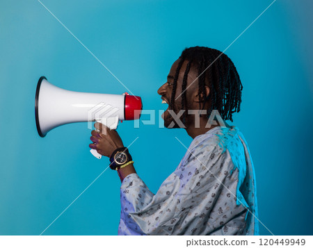 African American man dons traditional attire, passionately utilizing a megaphone against a striking blue background, symbolizing his vocal and cultural empowerment in the pursuit of social justice and African American man dons traditional attire, passionately utilizing a megaphone against a striking blue background, symbolizing his vocal and cultural empowerment in the pursuit of social justice and 120449949