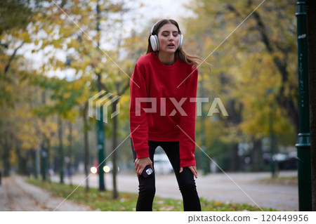 Athletic young woman taking a breath and relaxing after jogging and stretching. Woman Training and Workout Exercises On Street. Athletic young woman taking a breath and relaxing after jogging and stretching. Woman Training and Workout Exercises On Street. 120449956