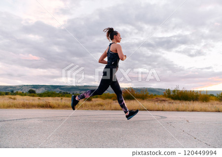 Determined Athlete Running in the Sun amidst Beautiful Nature 120449994