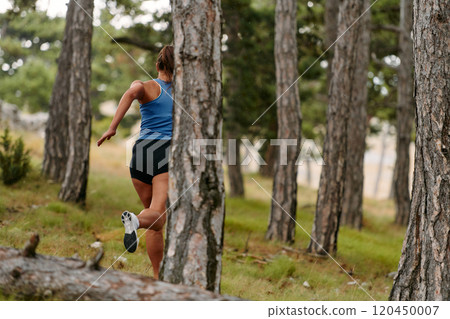 Fearless Woman Conquering Wooden Obstacles in the Dangerous Forest Terrain. 120450007