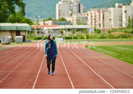 A muslim woman in a burqa sports muslim clothes running on a marathon course and preparing for upcoming competitions A muslim woman in a burqa sports muslim clothes running on a marathon course and preparing for upcoming competitions 120450021