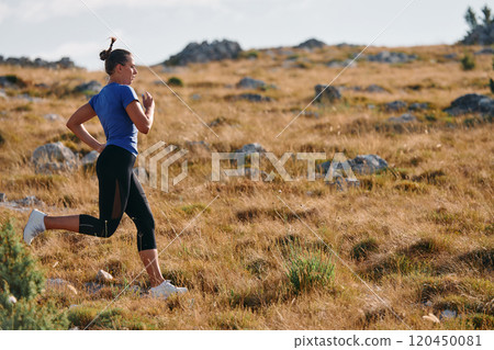 Empowered Runner Embracing Nature's Beauty on a Serene Morning Trail. 120450081