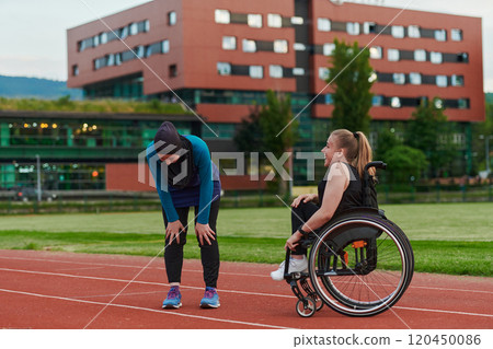 A Muslim woman wearing a burqa resting with a woman with disability after a hard training session on the marathon course A Muslim woman wearing a burqa resting with a woman with disability after a hard training session on the marathon course 120450086
