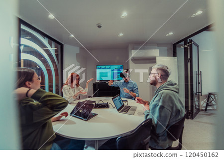 A diverse group of businessmen collaborates and tests a new virtual reality technology, wearing virtual glasses, showcasing innovation and creativity in their futuristic workspace 120450162