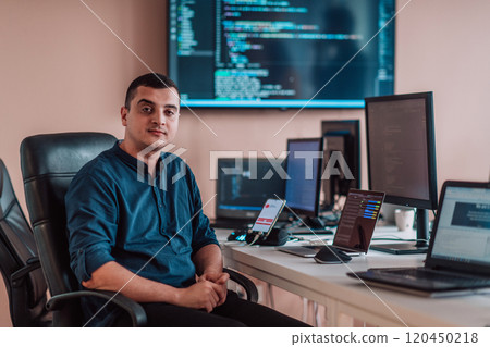 A programmer diligently testing smartphone applications while sitting in their office. 120450218