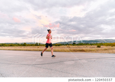 Determined Athlete Running in the Sun amidst Beautiful Nature 120450337