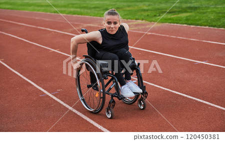 A woman with disablity driving a wheelchair on a track while preparing for the Paralympic Games 120450381