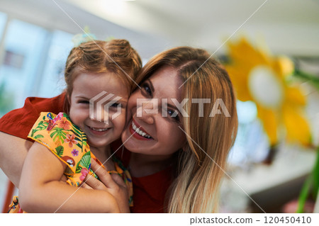 A cute little girl kissing and hugs her mother in preschool A cute little girl kissing and hugs her mother in preschool 120450410