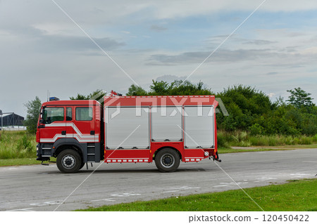 In this captivating scene, a state-of-the-art firetruck, equipped with advanced rescue technology, stands ready with its skilled firefighting team, prepared to intervene and respond rapidly to In this captivating scene, a state-of-the-art firetruck, equipped with advanced rescue technology, stands ready with its skilled firefighting team, prepared to intervene and respond rapidly to 120450422