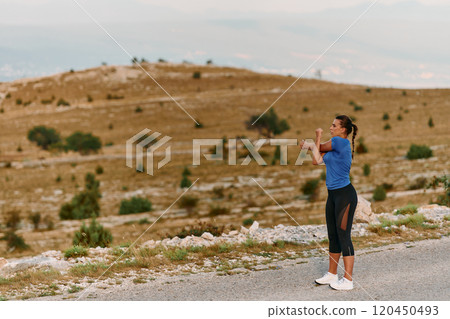 Determined Female Athlete Stretching After an Intense Run Through Rugged Mountain Terrain. 120450493