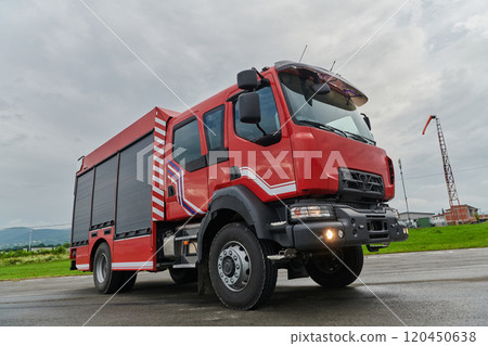 In this captivating scene, a state-of-the-art firetruck, equipped with advanced rescue technology, stands ready with its skilled firefighting team, prepared to intervene and respond rapidly to 120450638