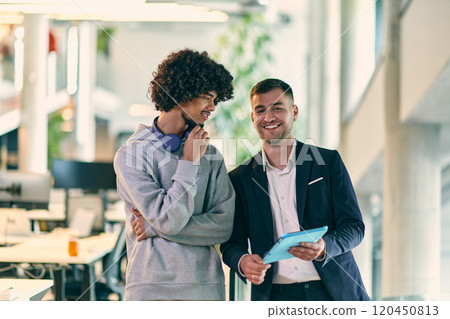 In a modern office setting, an African American businessman engages in a discussion with his director, using a tablet to address business challenges, symbolizing collaboration and technology In a modern office setting, an African American businessman engages in a discussion with his director, using a tablet to address business challenges, symbolizing collaboration and technology 120450813