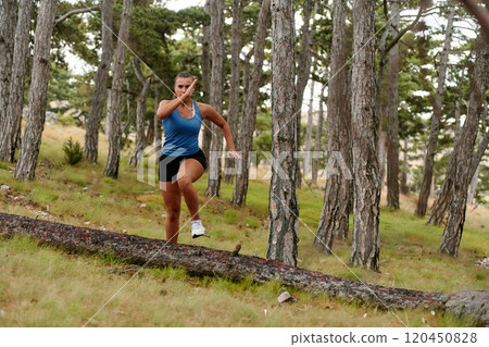 Fearless Woman Conquering Wooden Obstacles in the Dangerous Forest Terrain. Fearless Woman Conquering Wooden Obstacles in the Dangerous Forest Terrain. 120450828