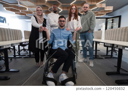 Young businessmen in a modern office extend a handshake to their business colleague in a wheelchair, showcasing inclusivity, support, and unity in the corporate environment. 120450832
