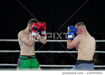 Fierce boxing match showcases athletes' power and skill. 120450843