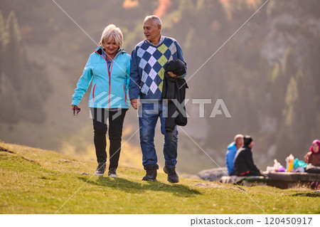 Elderly couple strolling through the breathtaking beauty of nature, maintaining their vitality and serenity, embracing the joys of a health-conscious and harmonious lifestyle Elderly couple strolling through the breathtaking beauty of nature, maintaining their vitality and serenity, embracing the joys of a health-conscious and harmonious lifestyle 120450917