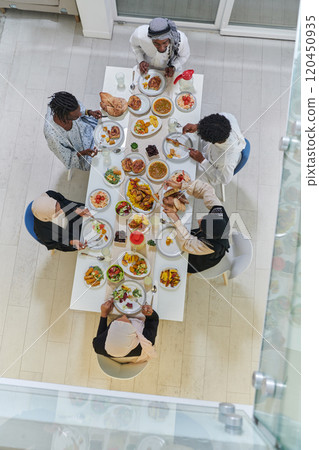 Top view of traditional and diverse Muslim family comes together to share a delicious iftar meal during the sacred month of Ramadan, embodying the essence of familial joy, cultural richness, and 120450935