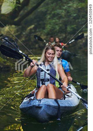 A group of friends enjoying having fun and kayaking while exploring the calm river, surrounding forest and large natural river canyons 120450949