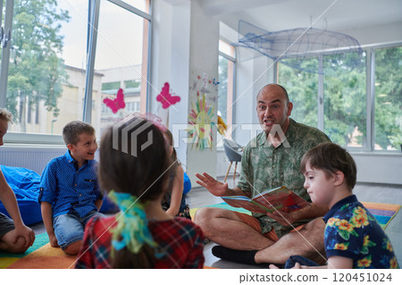 Reading time in an elementary school or kindergarten, a teacher reading a book to children in an elementary school or kindergarten. The concept of pre-school education. Selective focus 120451024