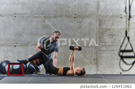 A muscular man assisting a fit woman in a modern gym as they engage in various body exercises and muscle stretches, showcasing their dedication to fitness and benefiting from teamwork and support A muscular man assisting a fit woman in a modern gym as they engage in various body exercises and muscle stretches, showcasing their dedication to fitness and benefiting from teamwork and support 120451062