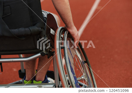 Close up photo of a person with disability in a wheelchair training tirelessly on the track in preparation for the Paralympic Games 120451096