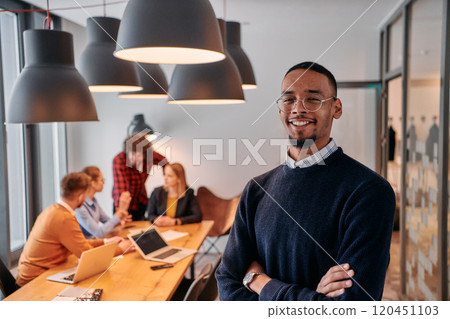 Startup Leadership: African American Businessman in Modern Office with Colleagues in Background. 120451103