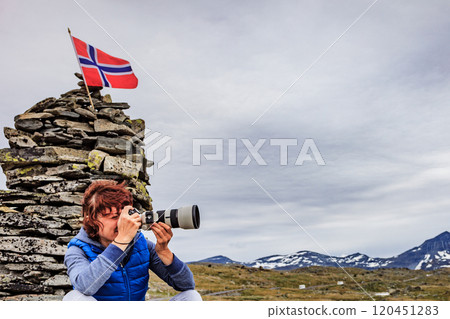 Tourist with camera in Norway mountains 120451283