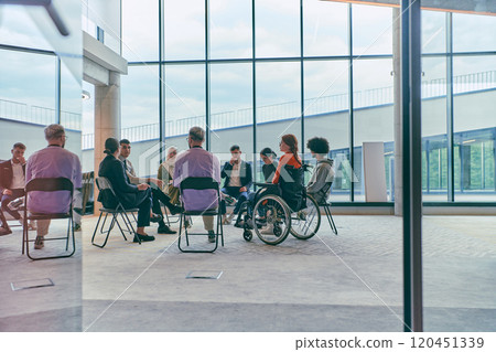 A diverse group of young business entrepreneurs gathered in a circle for a meeting, discussing corporate challenges and innovative solutions within the modern confines of a large corporation 120451339
