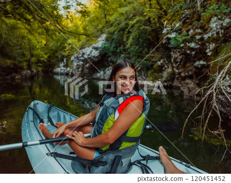 A smiling woman enjoying a relaxing kayak ride with a friend while exploring river canyons 120451452